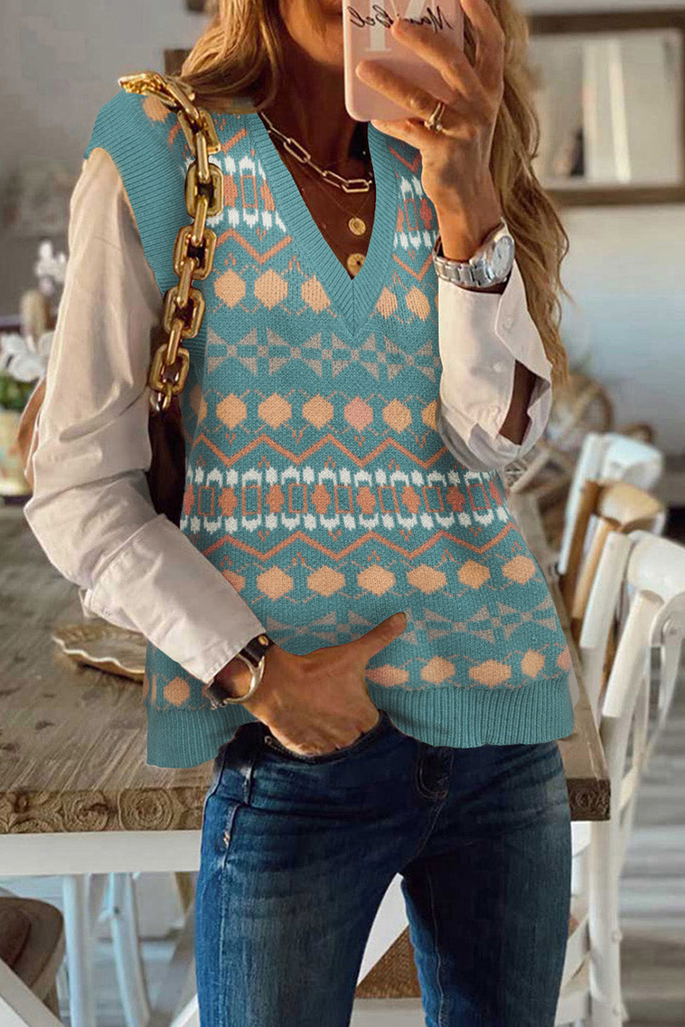 A stylish white knitted sweater vest featuring a unique tribal print design, perfect for layering during colder months.