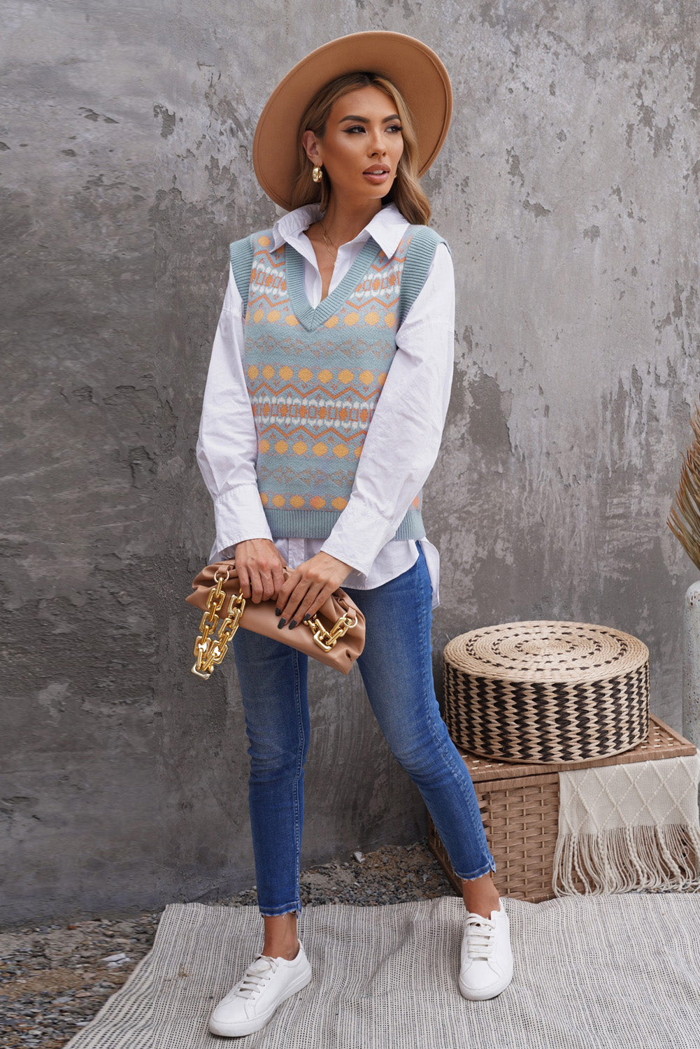 A stylish white knitted sweater vest featuring a unique tribal print design, perfect for layering during colder months.