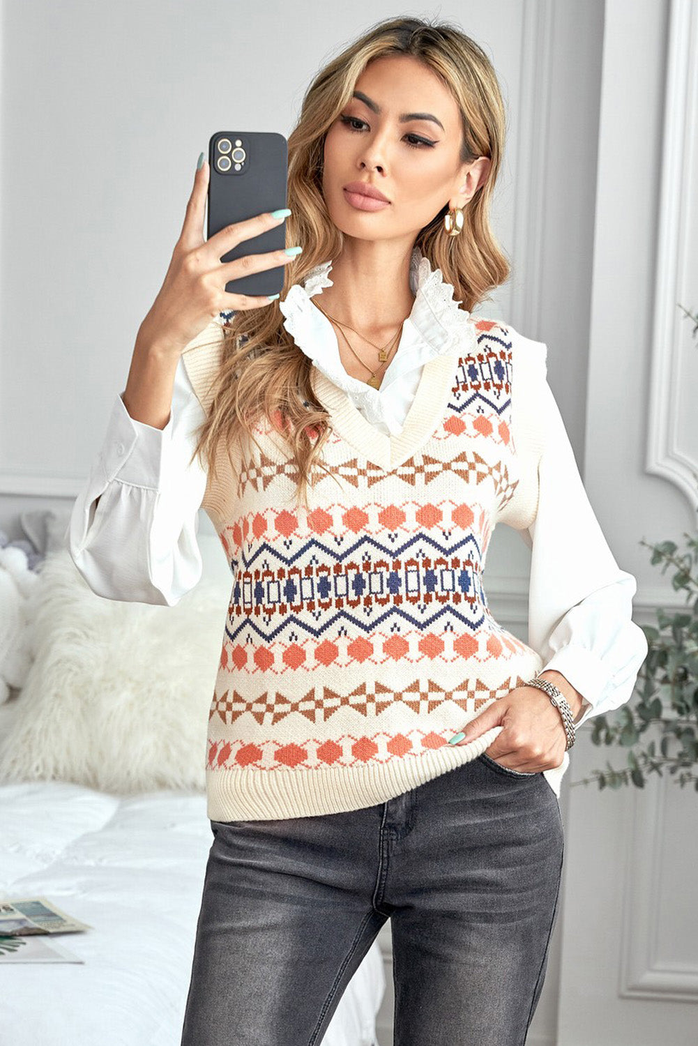 A stylish white knitted sweater vest featuring a unique tribal print design, perfect for layering during colder months.