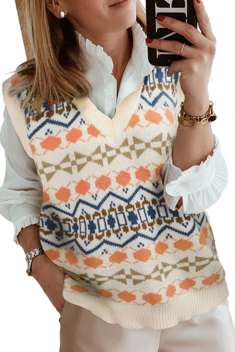 A stylish white knitted sweater vest featuring a unique tribal print design, perfect for layering during colder months.