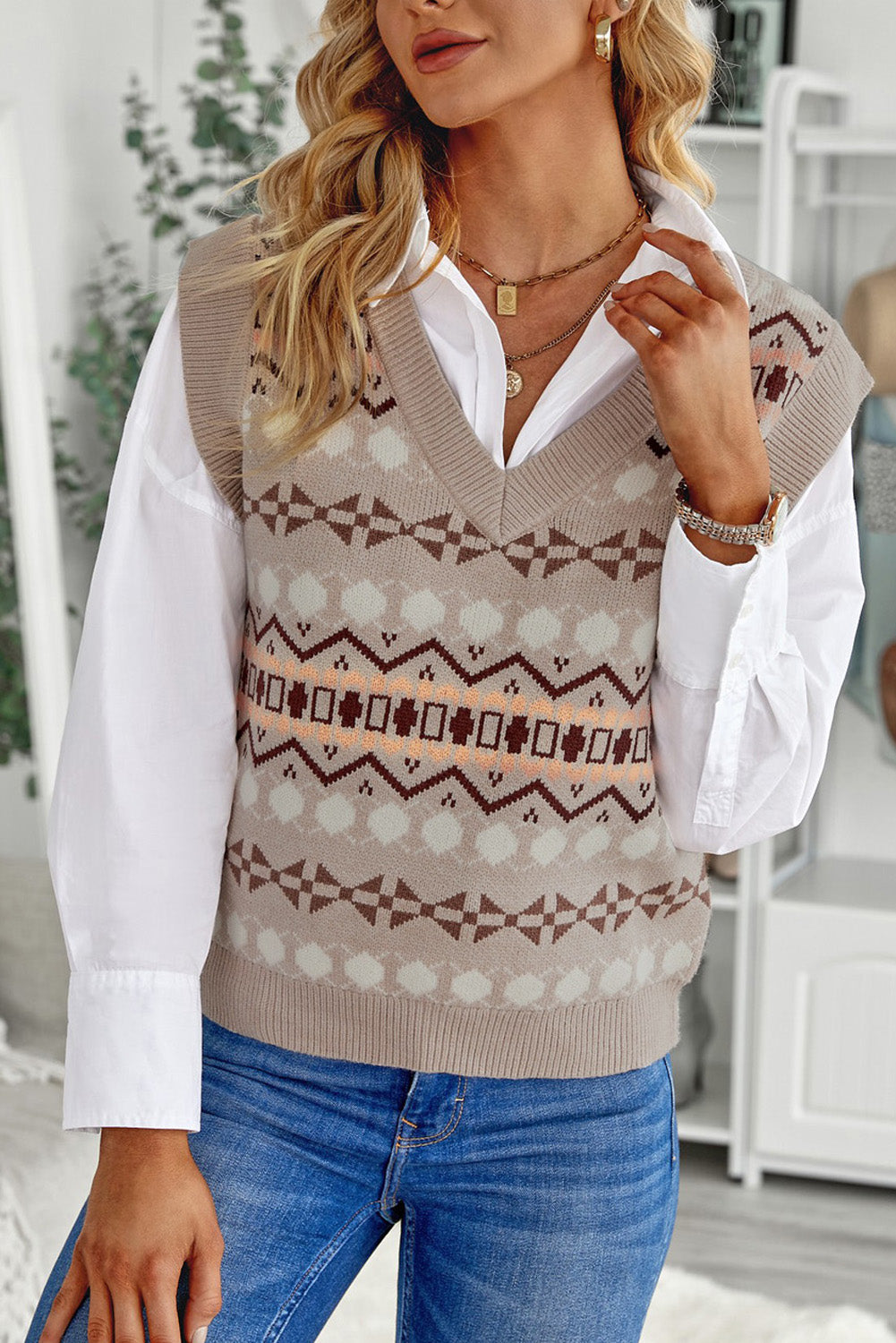 A stylish white knitted sweater vest featuring a unique tribal print design, perfect for layering during colder months.