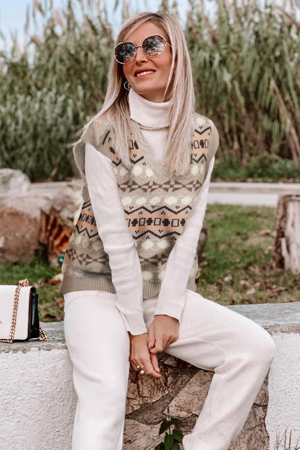 A stylish white knitted sweater vest featuring a unique tribal print design, perfect for layering during colder months.