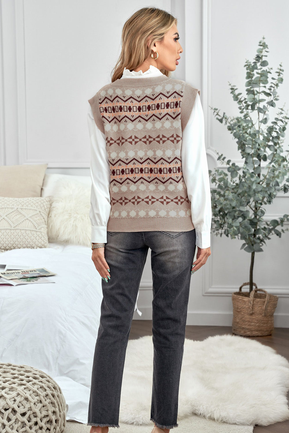 A stylish white knitted sweater vest featuring a unique tribal print design, perfect for layering during colder months.