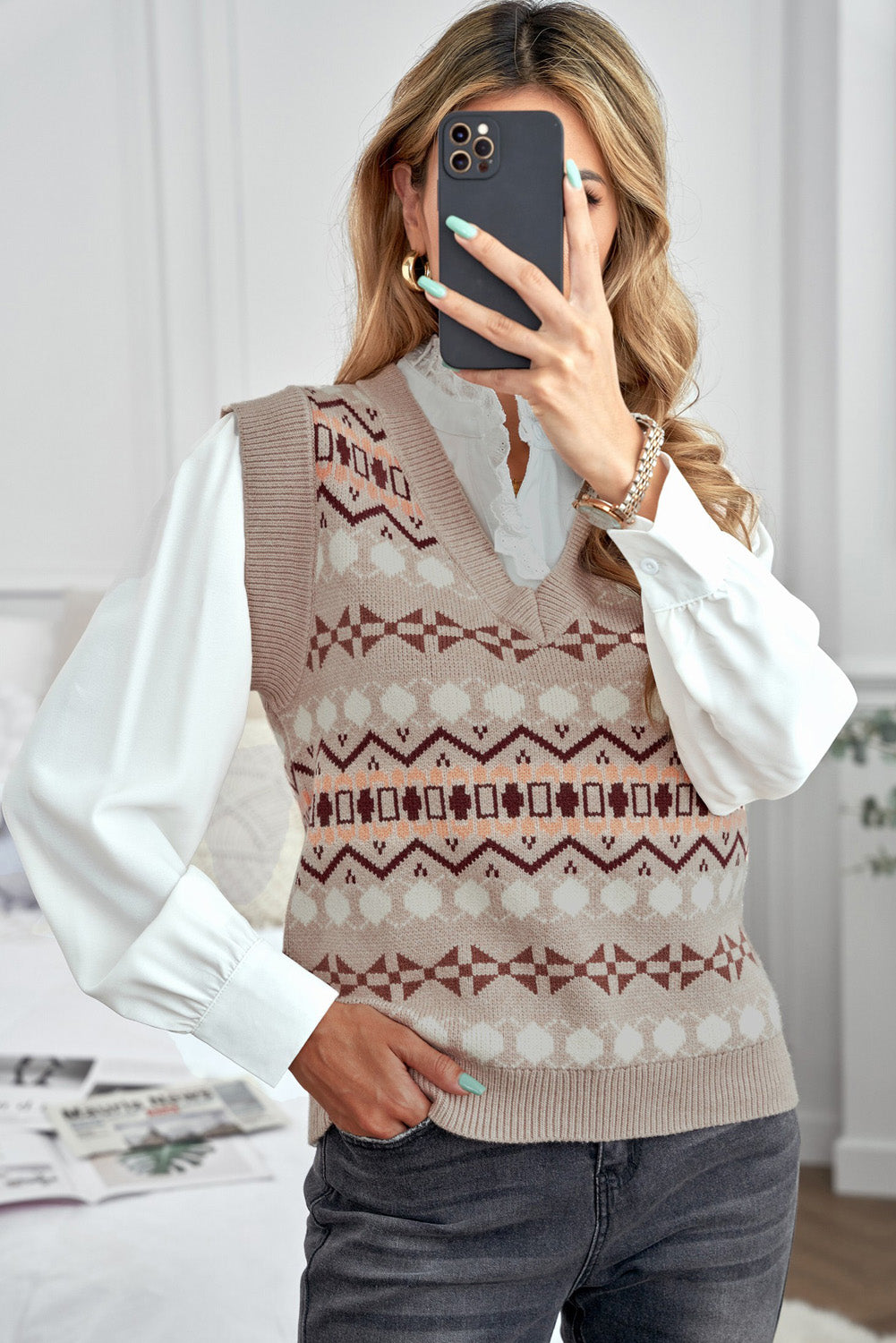 A stylish white knitted sweater vest featuring a unique tribal print design, perfect for layering during colder months.