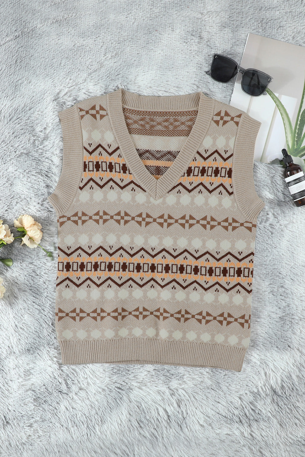 A stylish white knitted sweater vest featuring a unique tribal print design, perfect for layering during colder months.