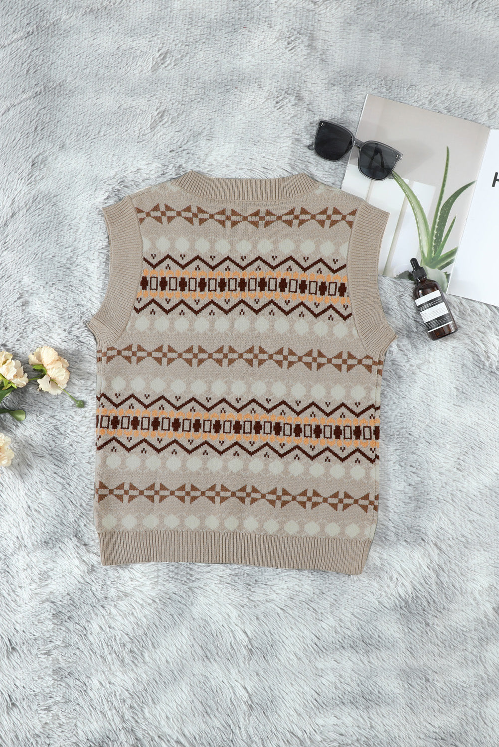 A stylish white knitted sweater vest featuring a unique tribal print design, perfect for layering during colder months.