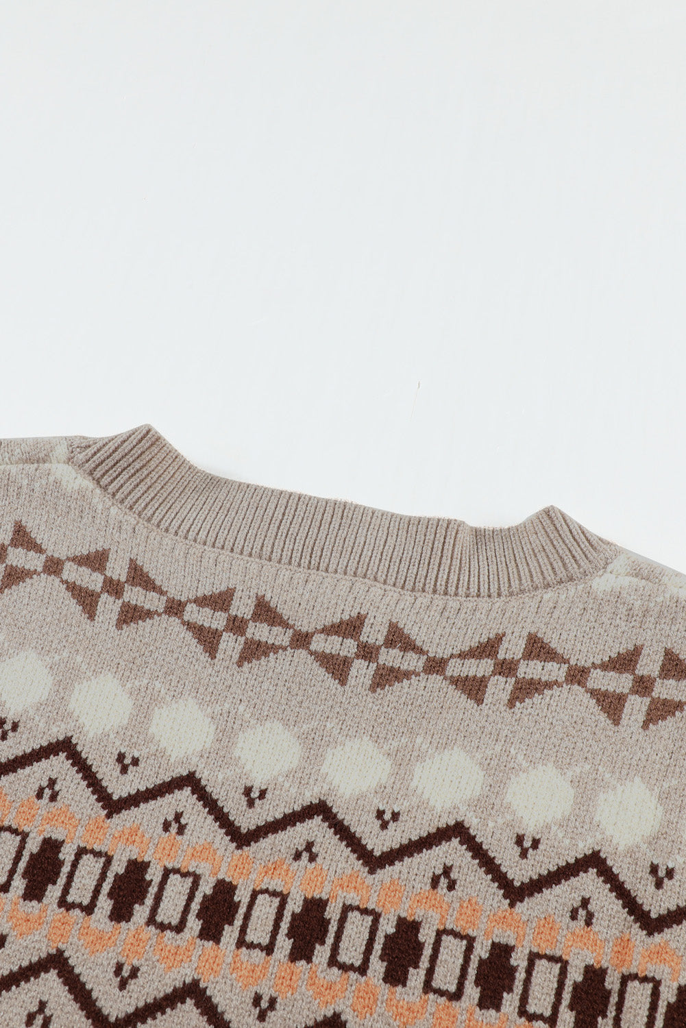 A stylish white knitted sweater vest featuring a unique tribal print design, perfect for layering during colder months.