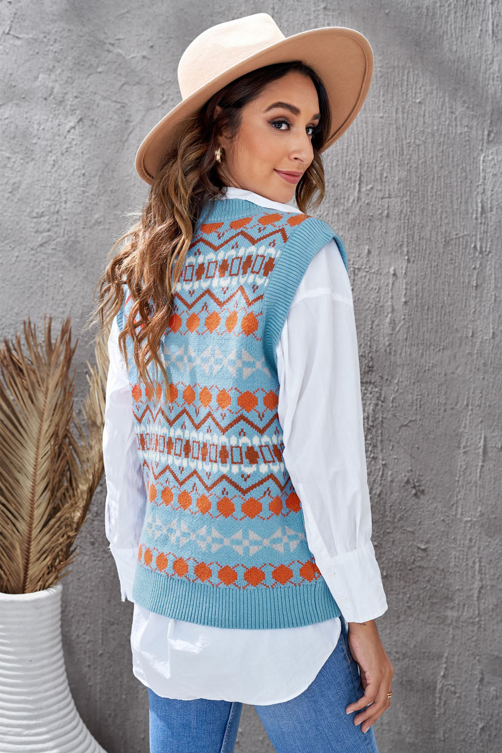 A stylish white knitted sweater vest featuring a unique tribal print design, perfect for layering during colder months.