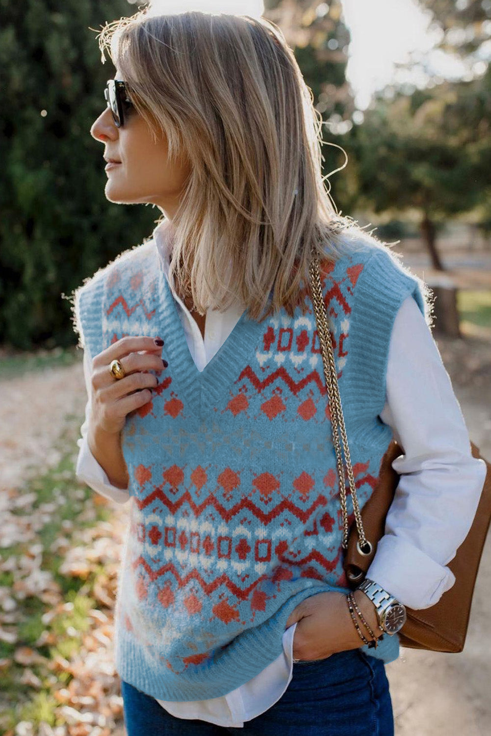 A stylish white knitted sweater vest featuring a unique tribal print design, perfect for layering during colder months.