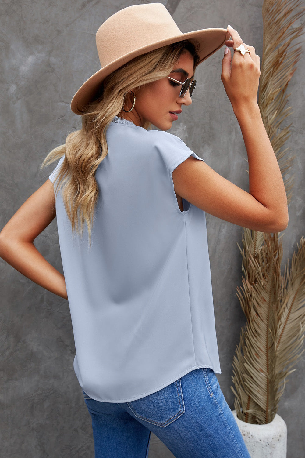 A stylish white V neck t-shirt featuring a delicate lace trim, showcasing its relaxed fit and elegant design.