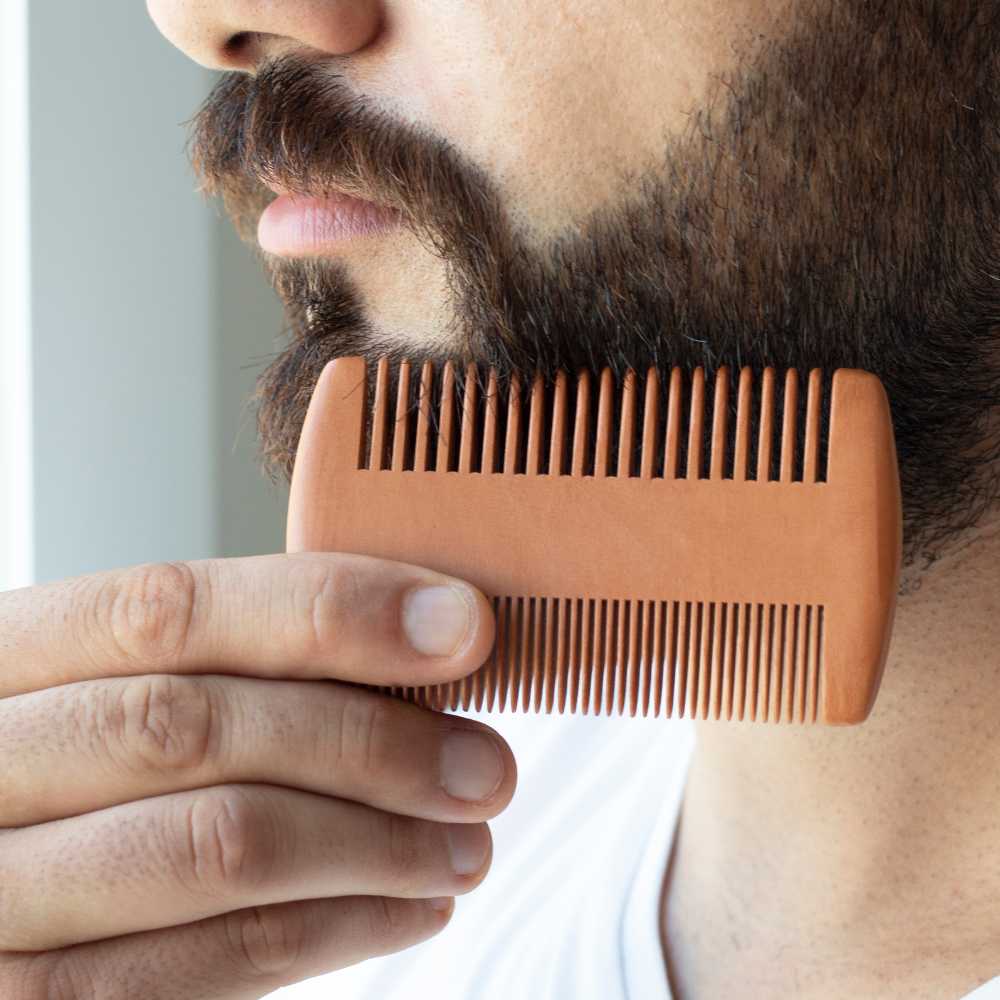 A wooden beard comb with an ergonomic design, showcasing its smooth finish and eco-friendly material, ideal for grooming beards without snagging.