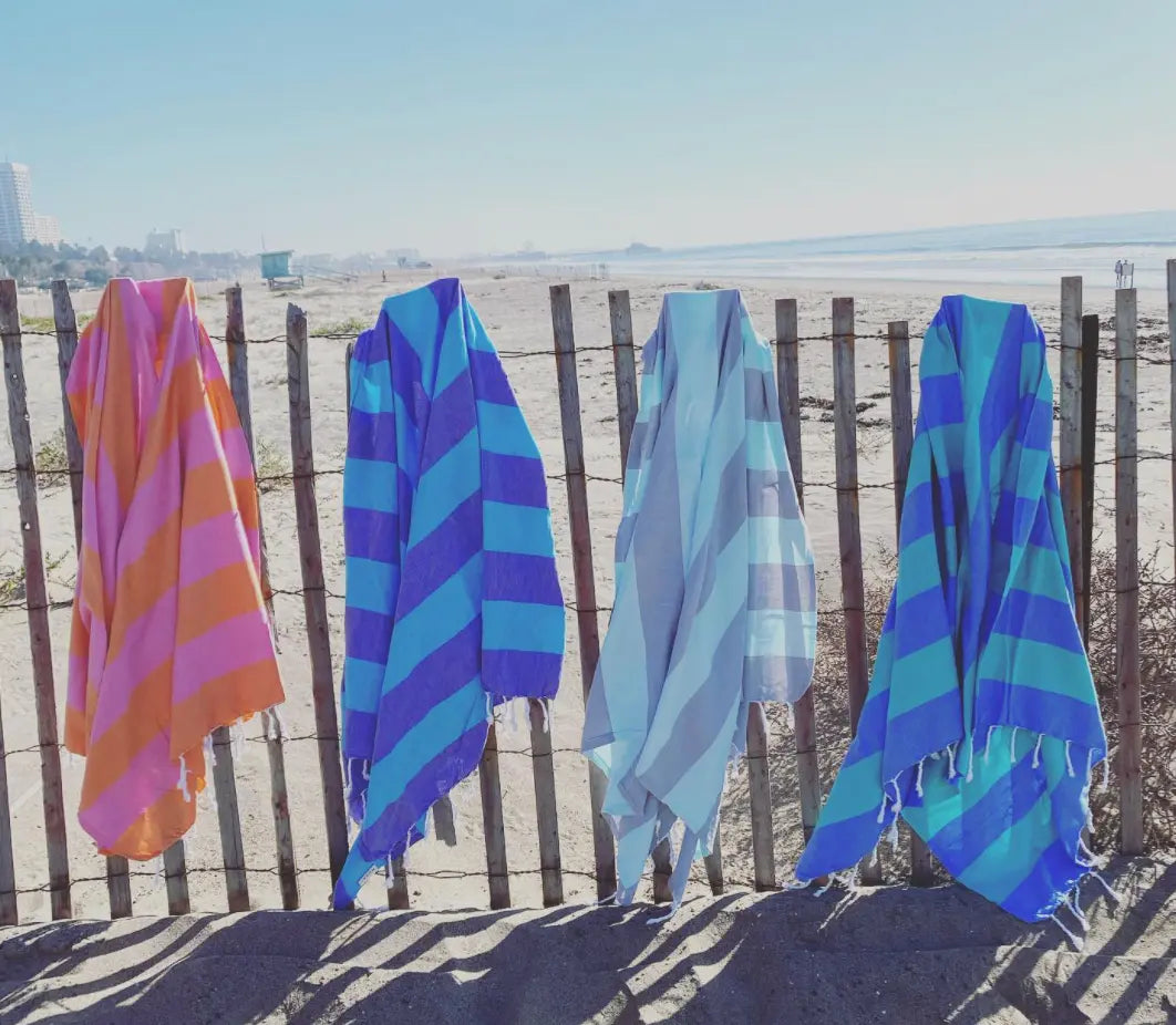 Zuma Turkish Towel featuring vibrant stripes and hand-twisted tassels, perfect for beach and pool use.