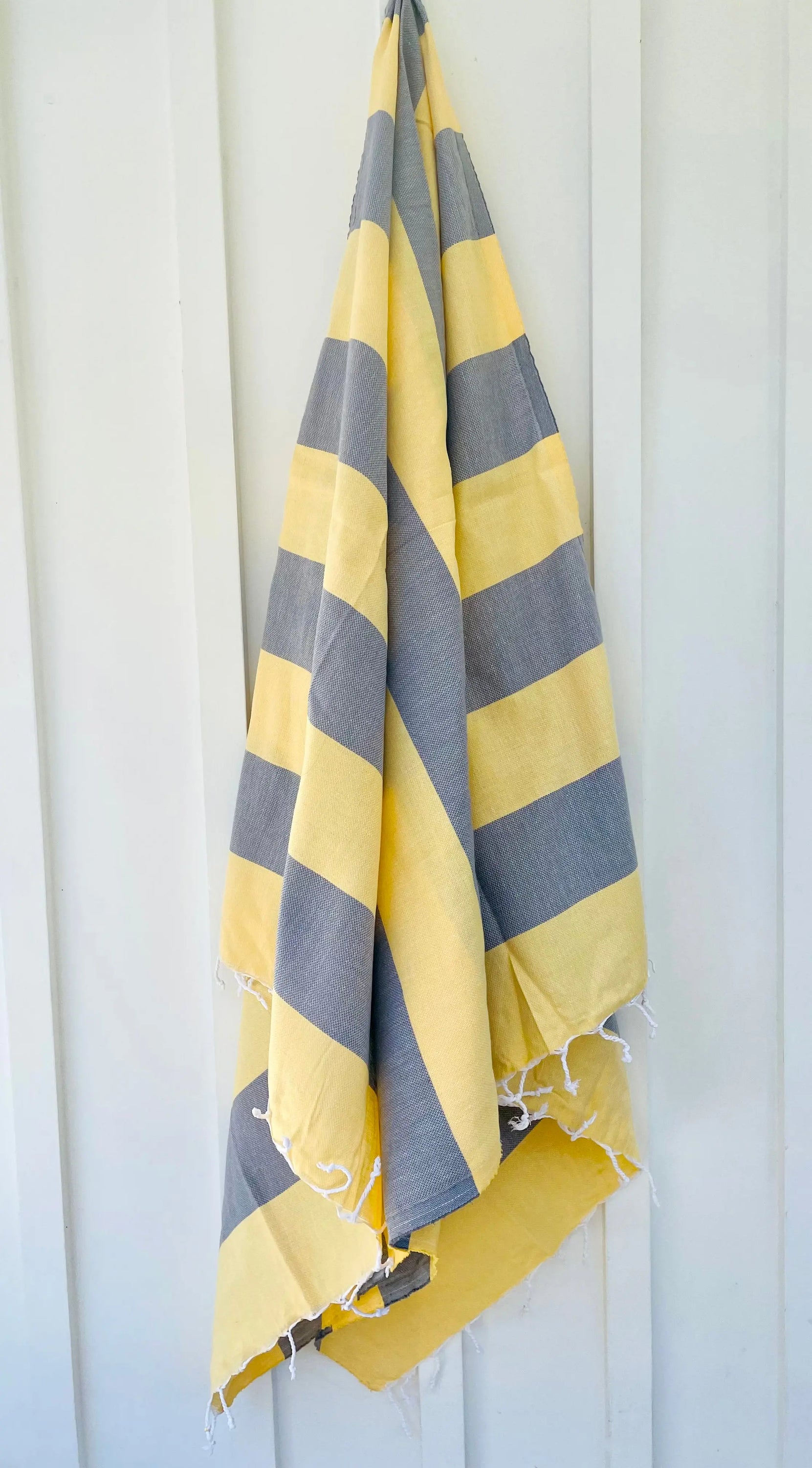 Zuma Turkish Towel featuring vibrant stripes and hand-twisted tassels, perfect for beach and pool use.