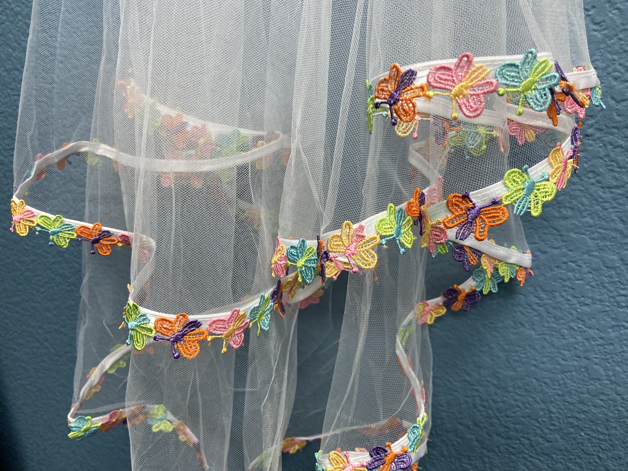 A vibrant 90's Retro Butterfly Bachelorette Party Veil with colorful butterfly trims and a secure hair comb, perfect for bachelorette celebrations.