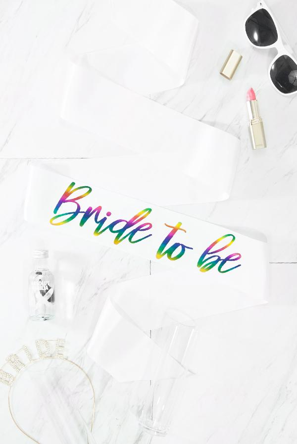 Bride To Be Foil Sash featuring vibrant rainbow foil on white satin ribbon, elegantly displayed in a box.