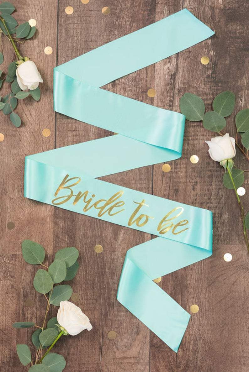 Bride To Be Gold Foil Sash in various colors, showcasing luxurious satin and shiny gold foil design.