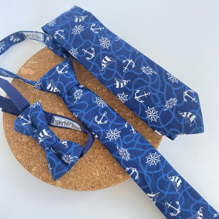 ERNEST Boys Bow Tie small in navy cotton with white nautical patterns, featuring sailing boats and anchors, perfect for young adventurers.