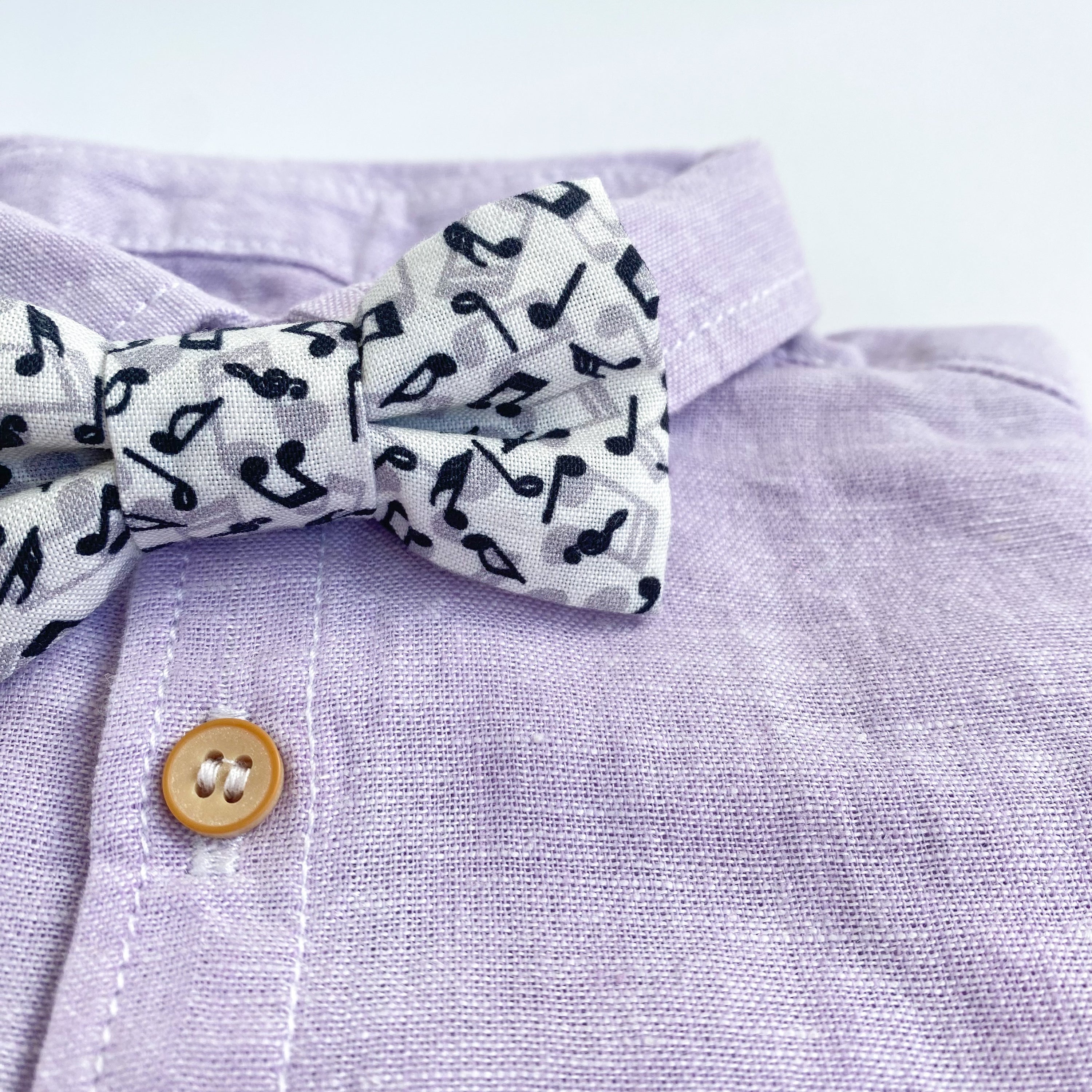 JONNY Musical Boys Bow Tie made of soft white cotton with black musical notes, pre-tied on a matching fabric strap.