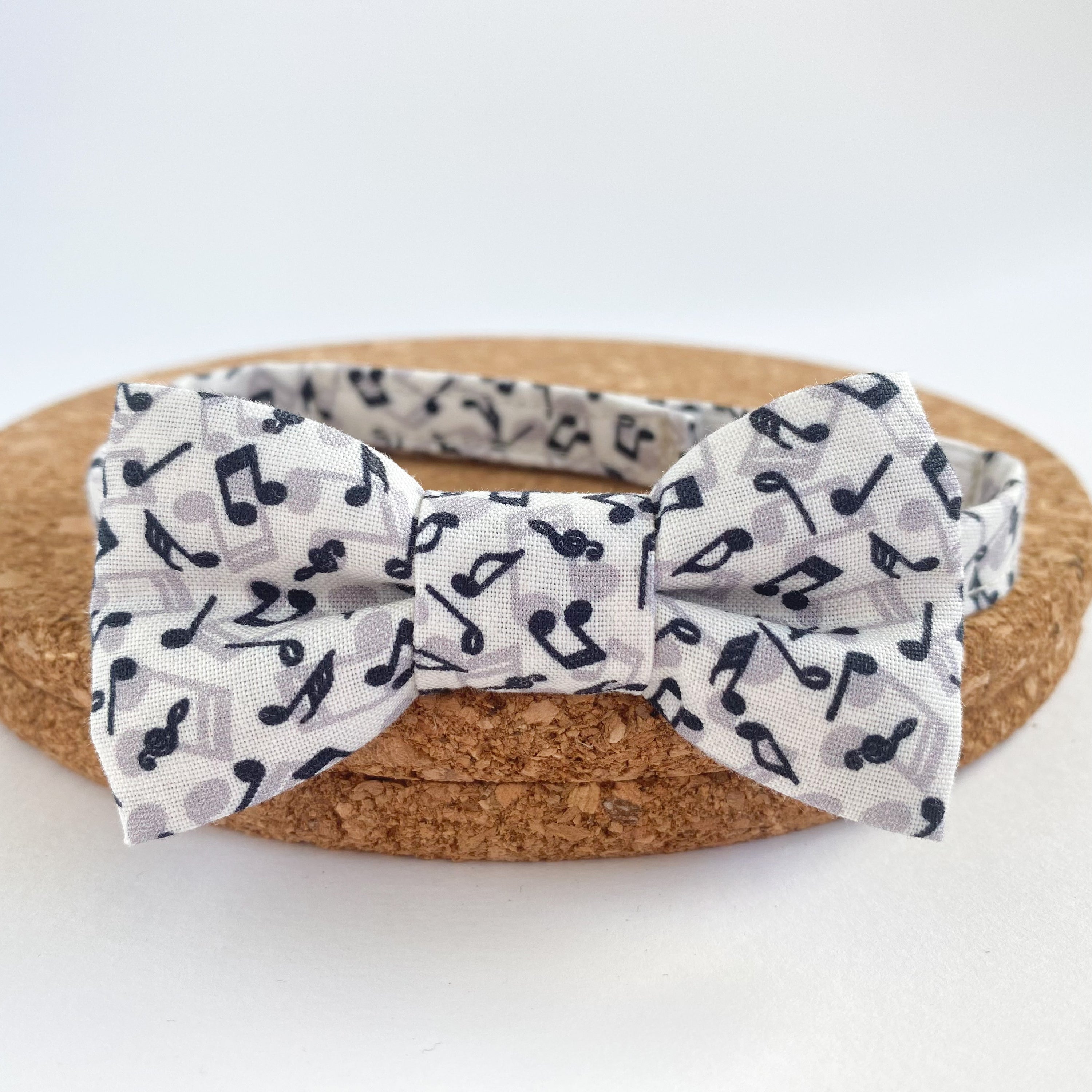 JONNY Musical Boys Bow Tie made of soft white cotton with black musical notes, pre-tied on a matching fabric strap.