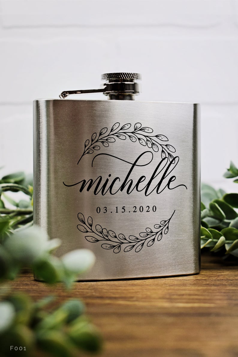 Silver flask engraved with foliage.