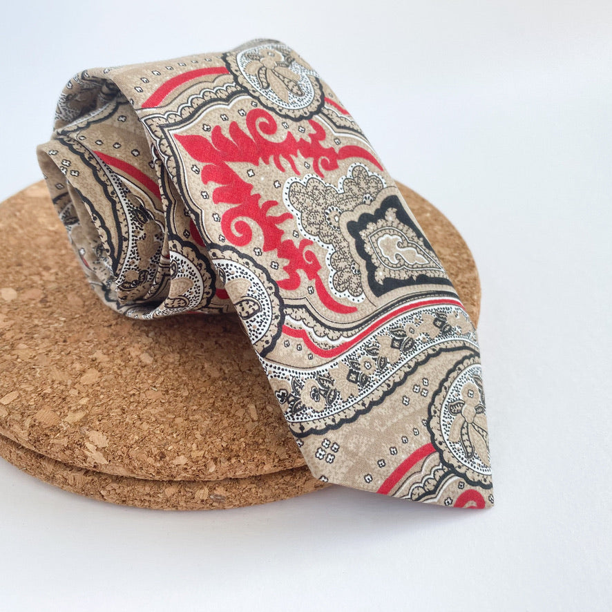 NICOLAS Mens Tie featuring a sophisticated paisley pattern in red and beige with black and white accents, handmade in England.