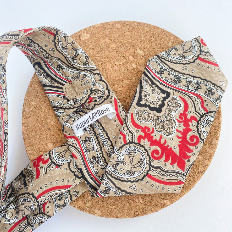 NICOLAS Mens Tie featuring a sophisticated paisley pattern in red and beige with black and white accents, handmade in England.