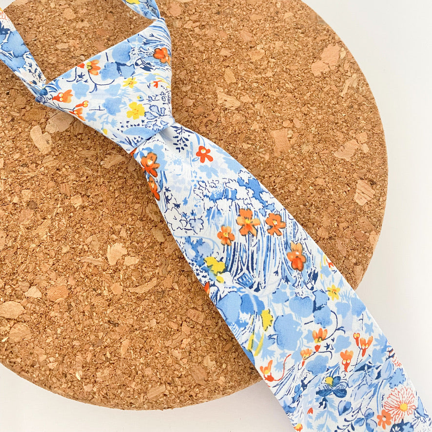 NOAH Floral Boys Velcro Ties featuring yellow and orange flowers on a blue background, perfect for summer events.