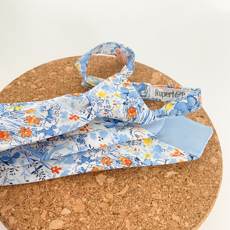 NOAH Floral Boys Velcro Ties featuring yellow and orange flowers on a blue background, perfect for summer events.