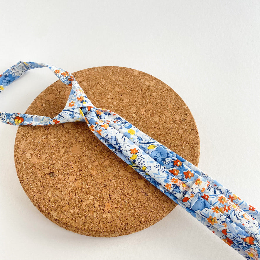 NOAH Floral Boys Velcro Ties featuring yellow and orange flowers on a blue background, perfect for summer events.