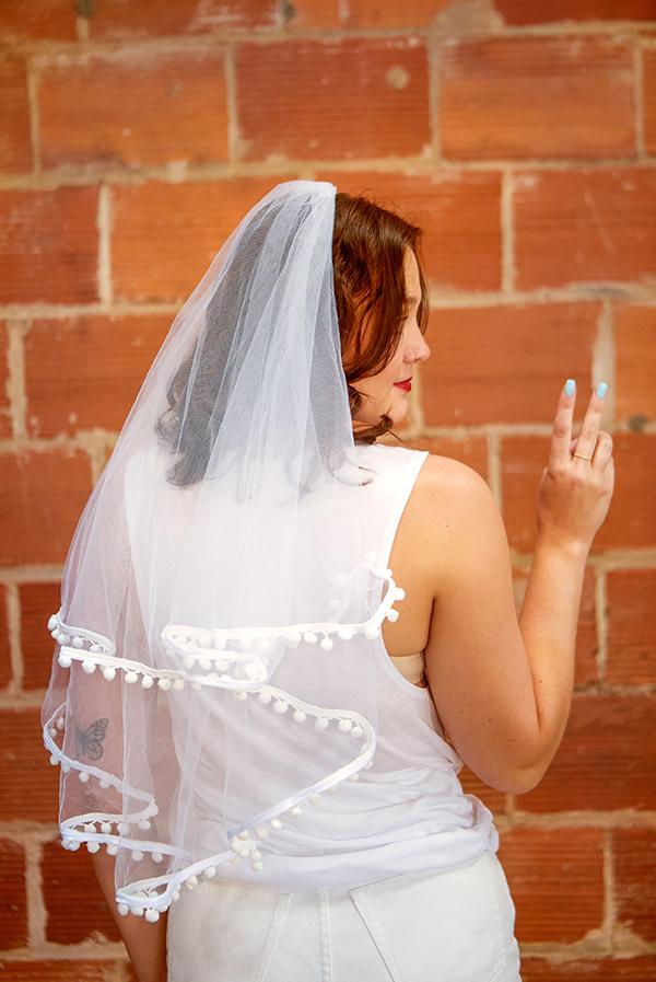 A beautiful White Pom Pom Bachelorette Party Veil featuring soft polyester fabric and playful pom-pom accents, secured with a versatile hair comb.