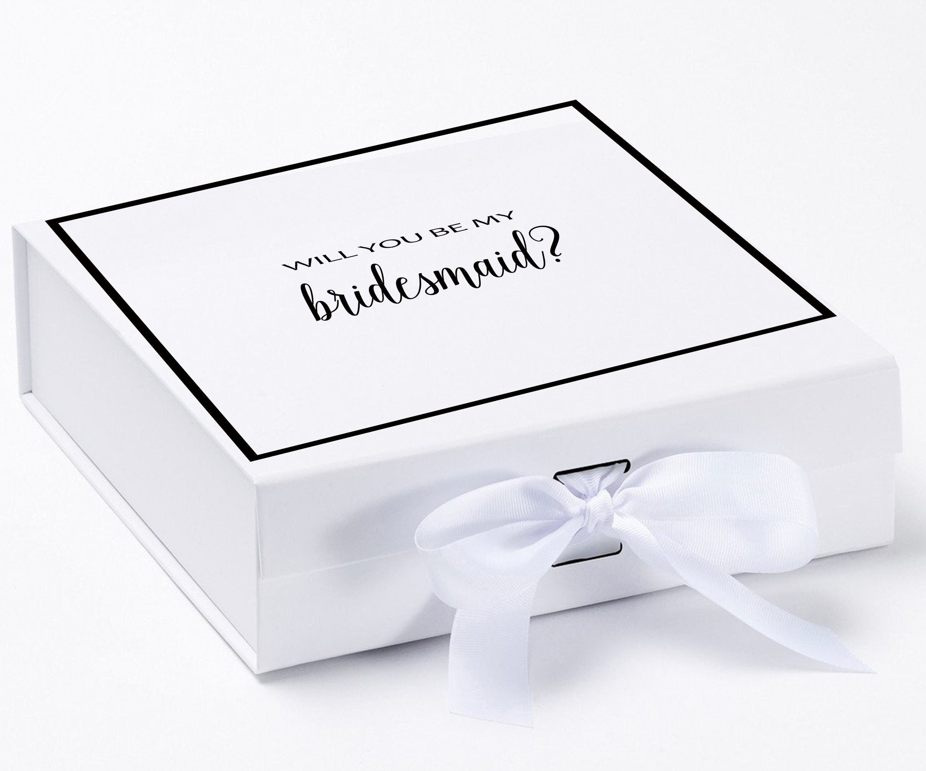 Elegant white gift box with gold metallic writing asking 'Will You Be My Bridesmaid', adorned with a black grosgrain ribbon.