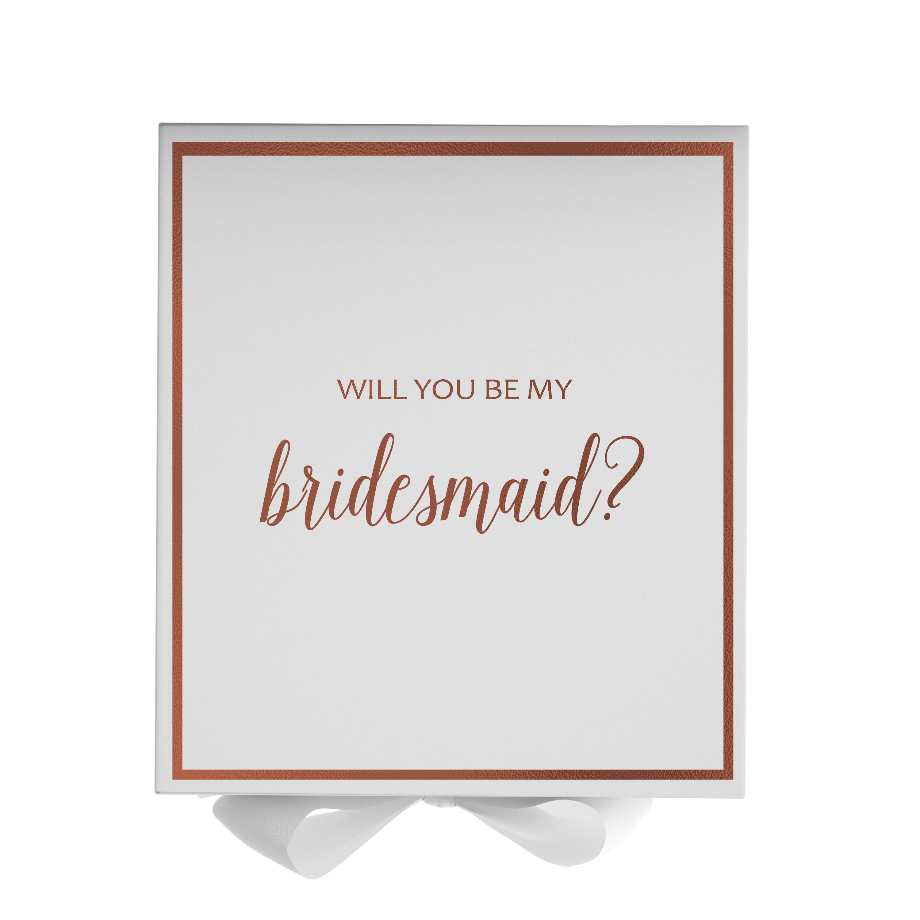 Elegant white gift box with gold metallic writing asking 'Will You Be My Bridesmaid', adorned with a black grosgrain ribbon.