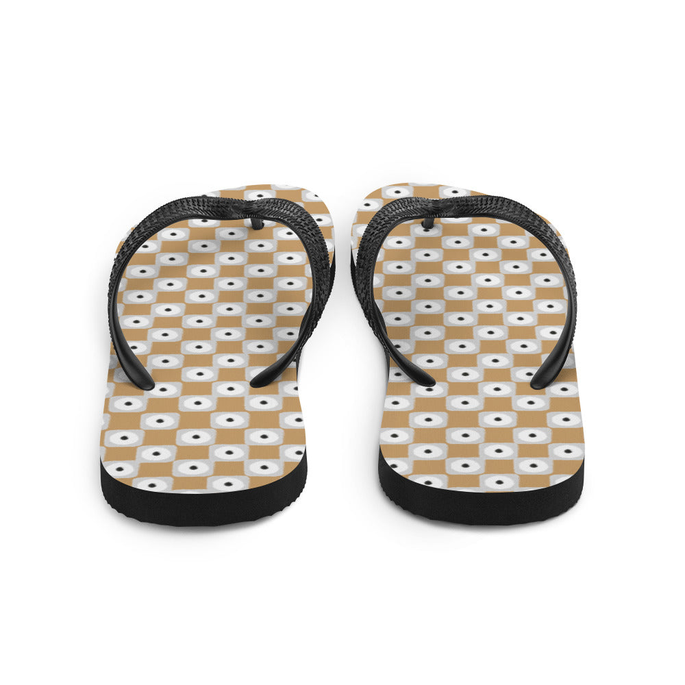 Beige and white chequered flip-flops with black rubber straps, showcasing a stylish and comfortable design for summer wear.