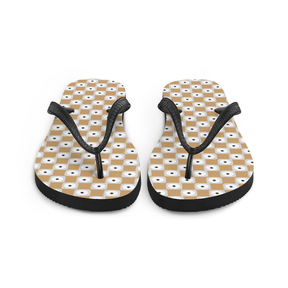 Beige and white chequered flip-flops with black rubber straps, showcasing a stylish and comfortable design for summer wear.