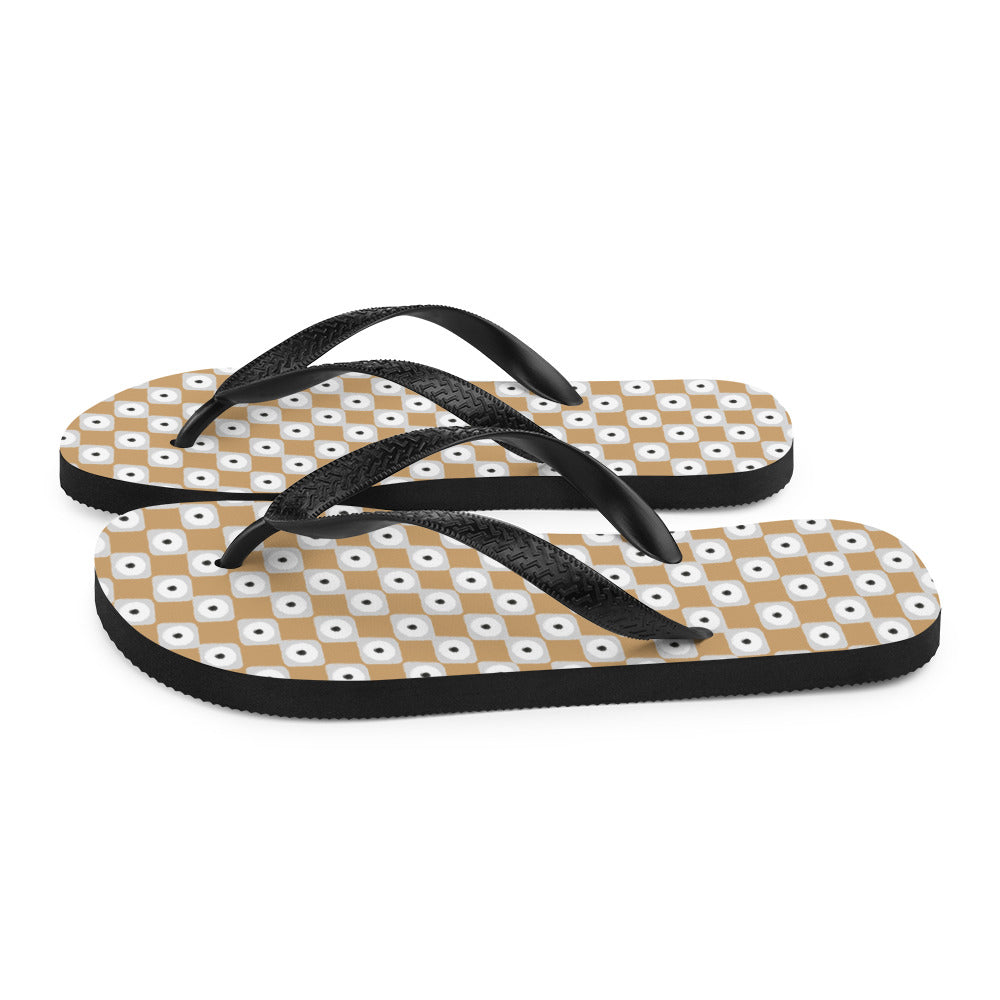 Beige and white chequered flip-flops with black rubber straps, showcasing a stylish and comfortable design for summer wear.