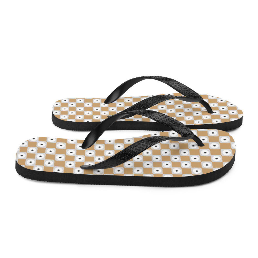 Beige and white chequered flip-flops with black rubber straps, showcasing a stylish and comfortable design for summer wear.