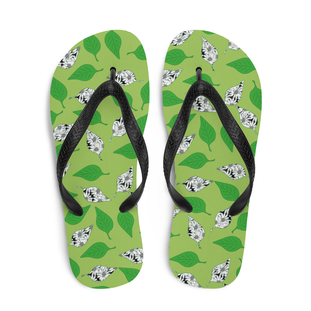 A pair of Green Leaf Print Flip-Flops featuring a vibrant leaf design, soft fabric lining, and black Y-shaped rubber straps, perfect for summer wear.