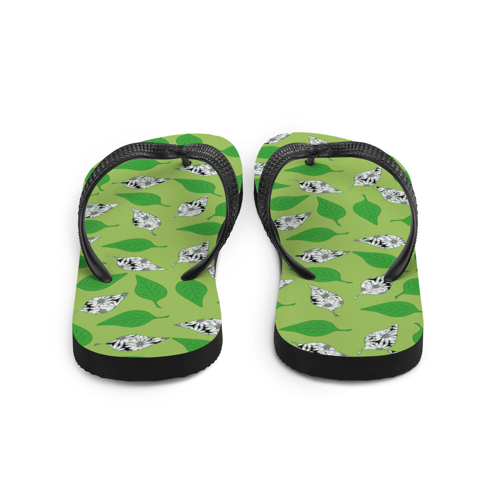 A pair of Green Leaf Print Flip-Flops featuring a vibrant leaf design, soft fabric lining, and black Y-shaped rubber straps, perfect for summer wear.