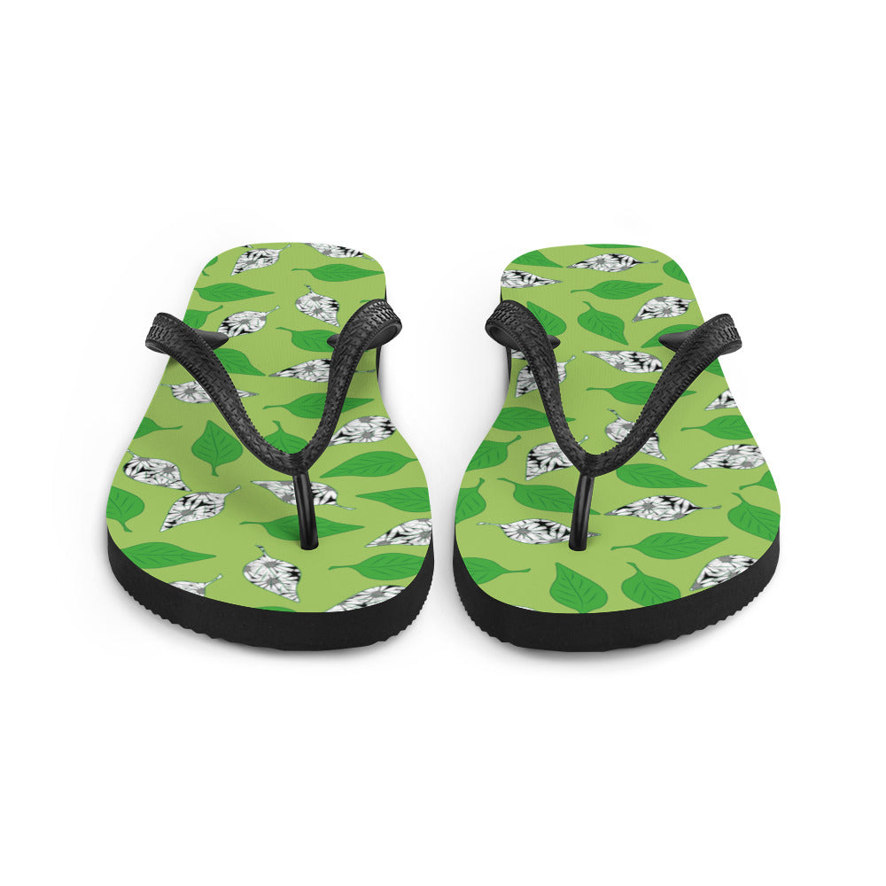 A pair of Green Leaf Print Flip-Flops featuring a vibrant leaf design, soft fabric lining, and black Y-shaped rubber straps, perfect for summer wear.