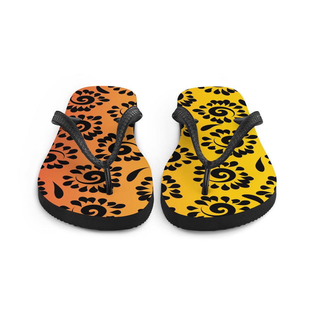 A pair of vibrant orange red black patterned flip-flops with a rubber sole and black Y-shaped straps, perfect for summer wear.