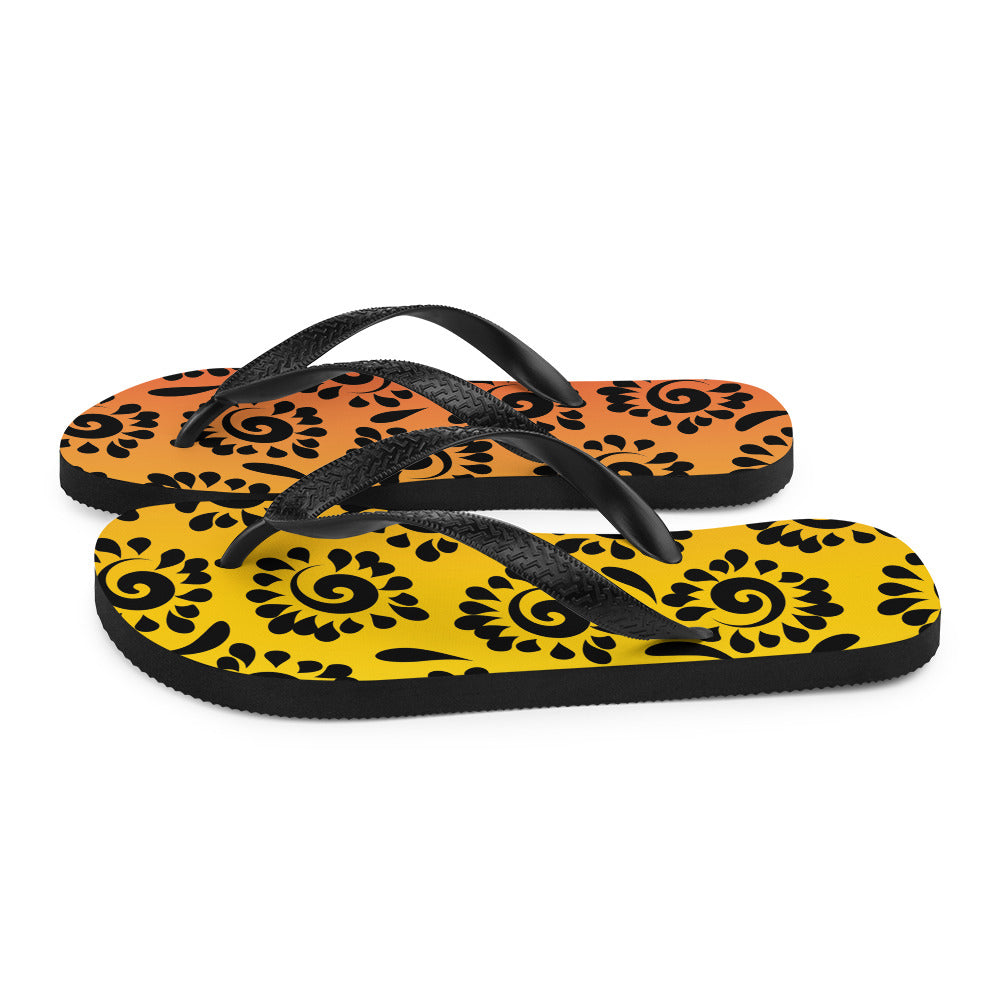 A pair of vibrant orange red black patterned flip-flops with a rubber sole and black Y-shaped straps, perfect for summer wear.