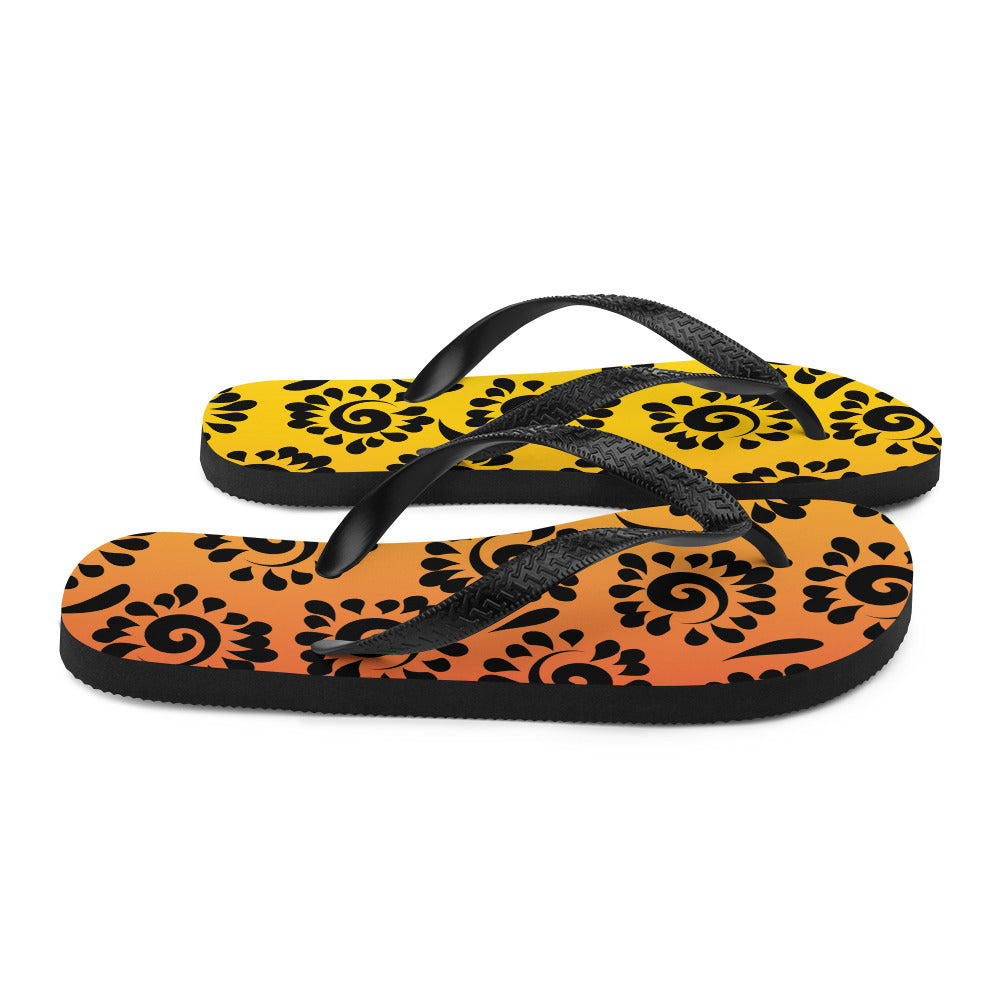 A pair of vibrant orange red black patterned flip-flops with a rubber sole and black Y-shaped straps, perfect for summer wear.