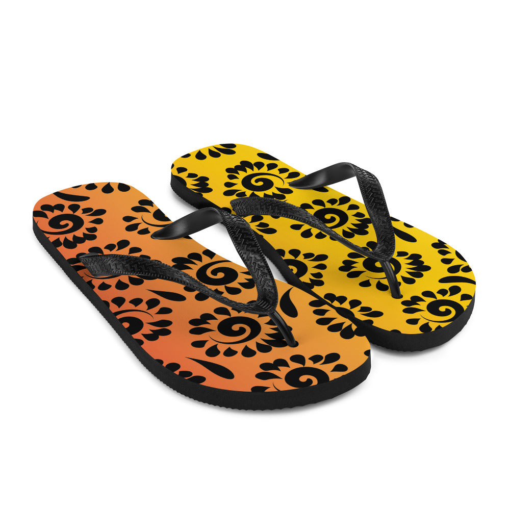 A pair of vibrant orange red black patterned flip-flops with a rubber sole and black Y-shaped straps, perfect for summer wear.