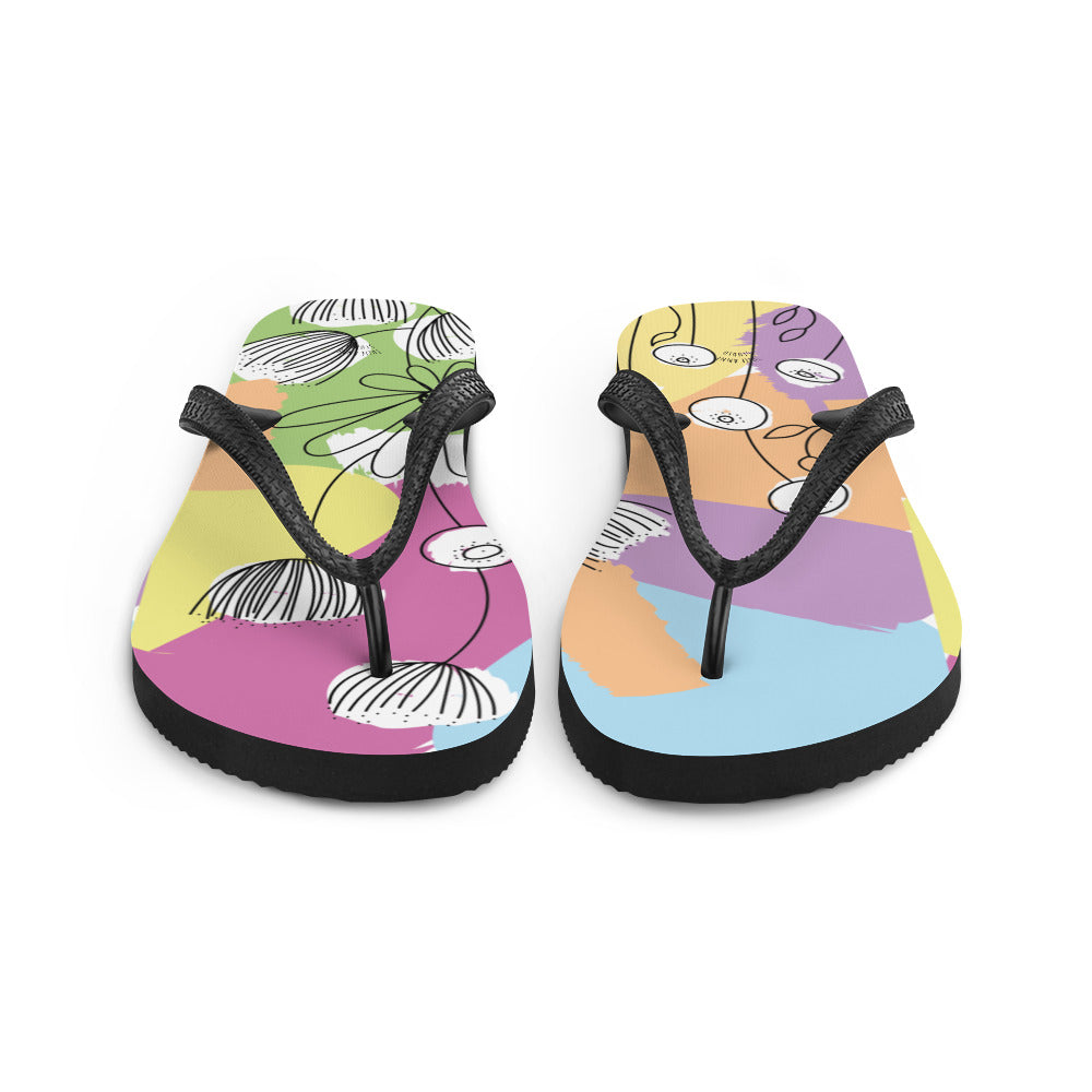 A pair of Pretty Pastel Flower Print Flip-Flops featuring a vibrant floral design, black rubber straps, and a soft fabric lining, perfect for summer wear.