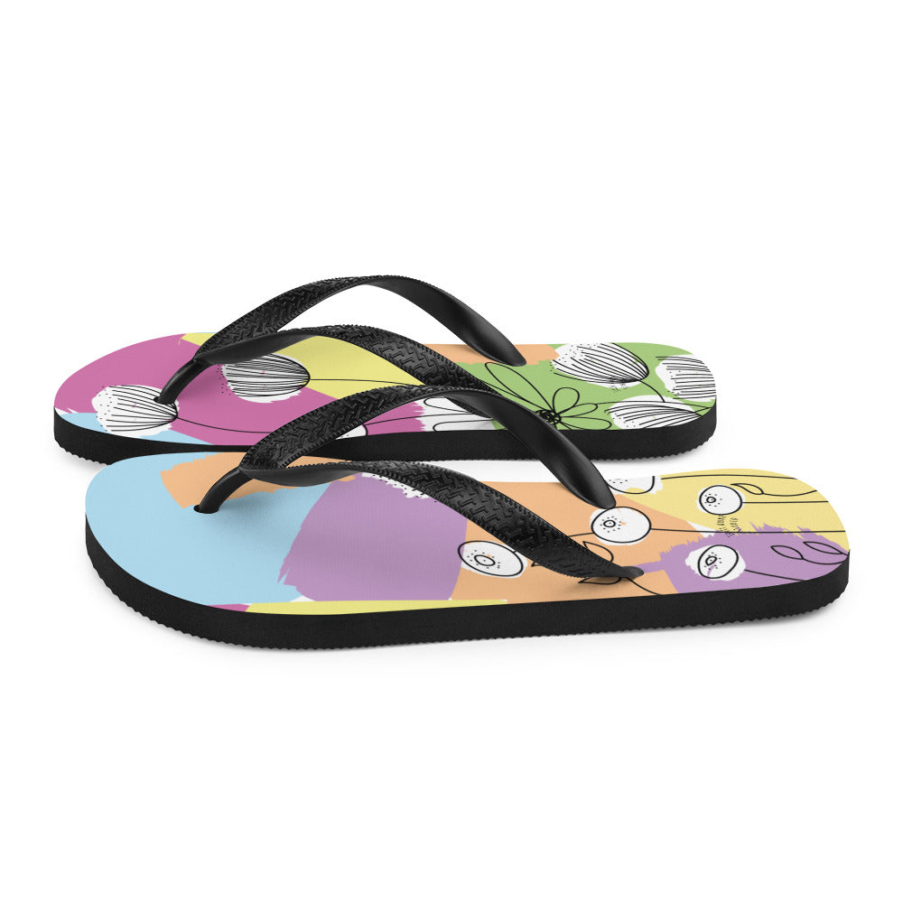 A pair of Pretty Pastel Flower Print Flip-Flops featuring a vibrant floral design, black rubber straps, and a soft fabric lining, perfect for summer wear.