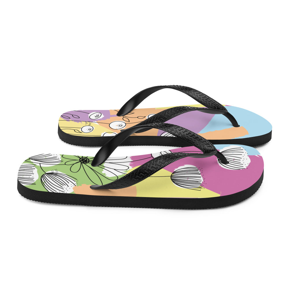 A pair of Pretty Pastel Flower Print Flip-Flops featuring a vibrant floral design, black rubber straps, and a soft fabric lining, perfect for summer wear.