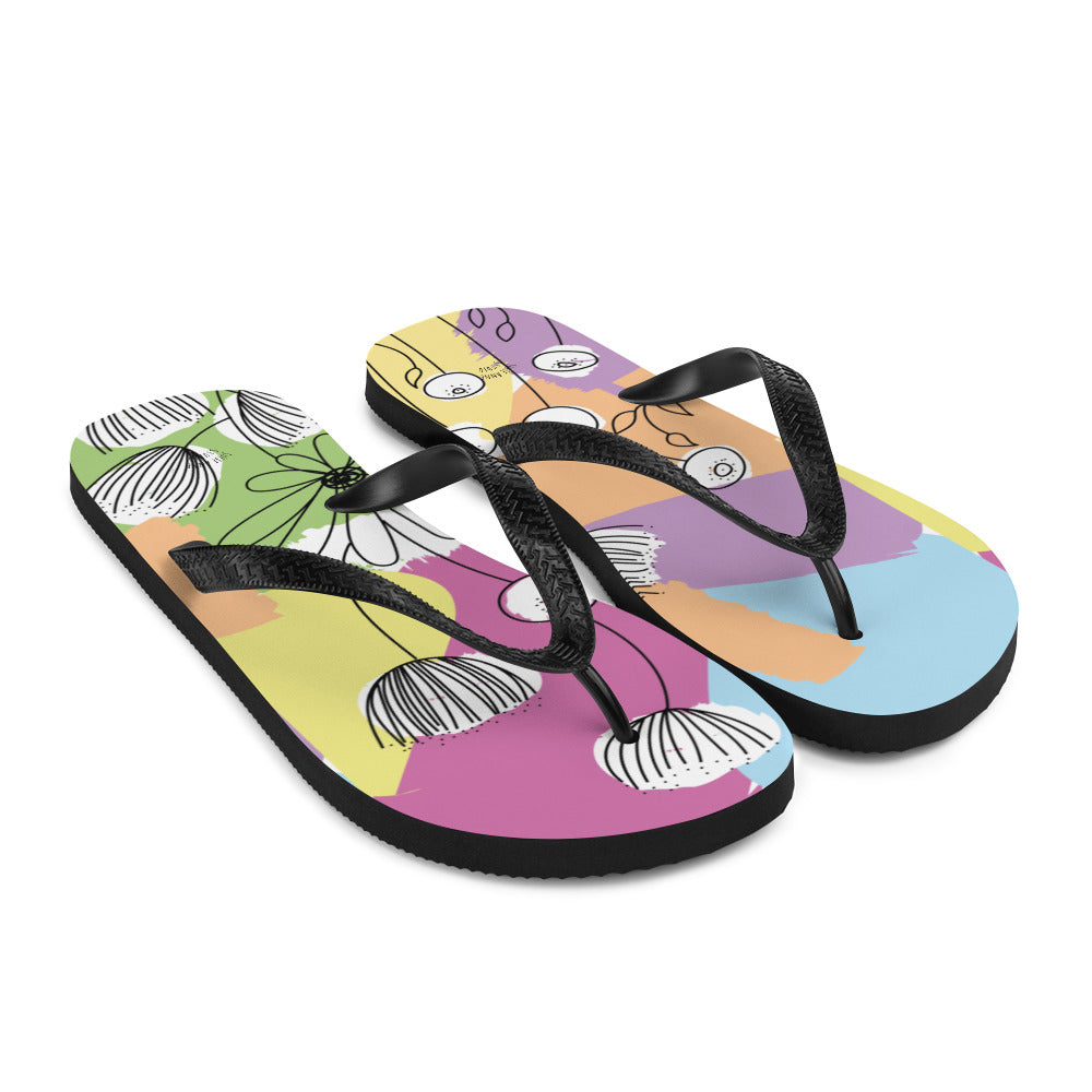 A pair of Pretty Pastel Flower Print Flip-Flops featuring a vibrant floral design, black rubber straps, and a soft fabric lining, perfect for summer wear.