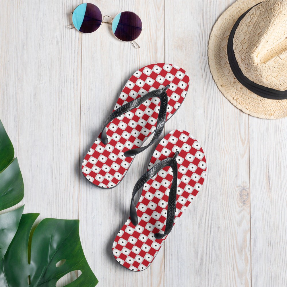 A pair of red chequered pattern flip-flops with black Y-shaped rubber straps and a soft fabric lining, perfect for summer wear.