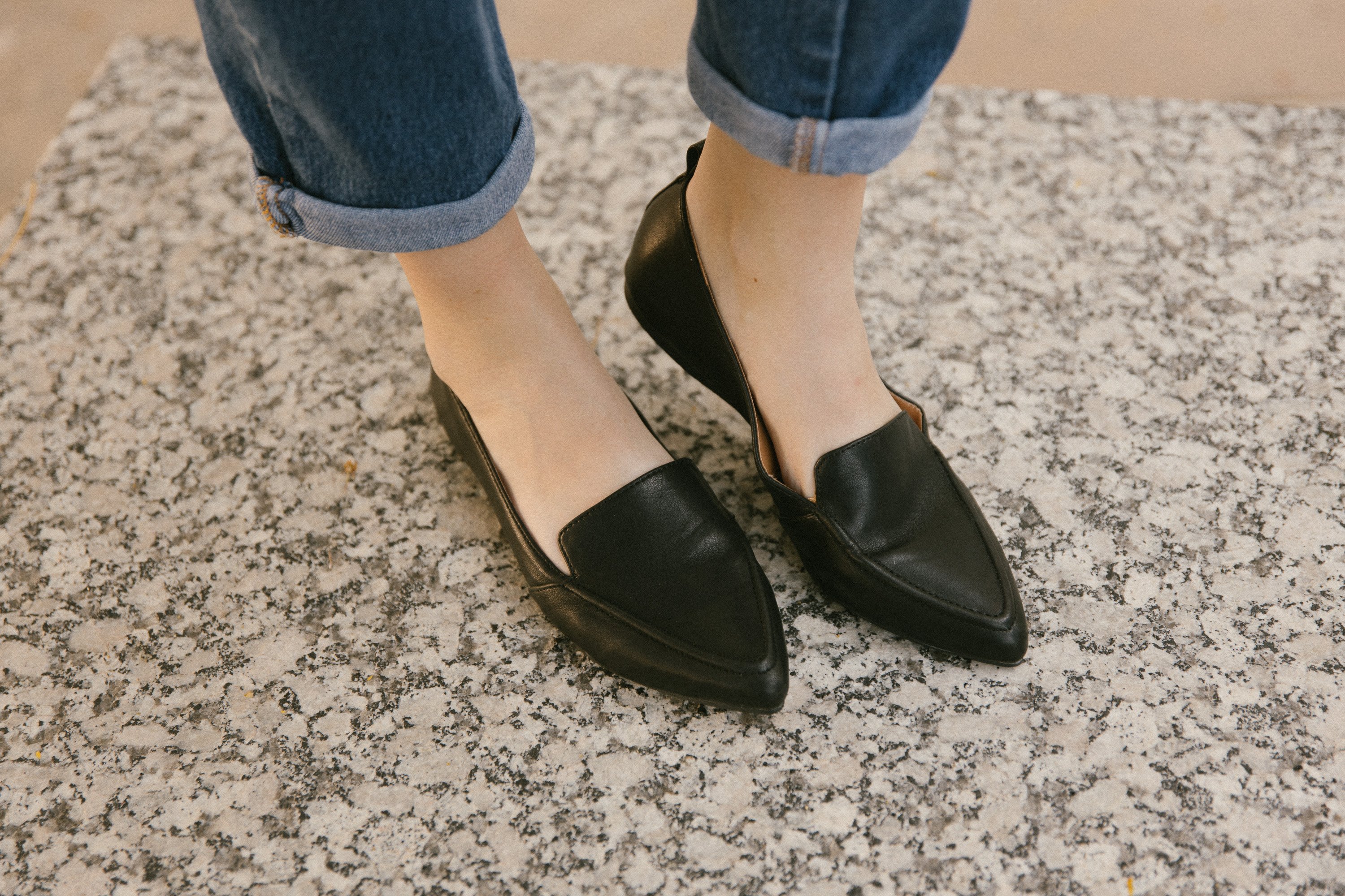 Person wearing black pointed flats