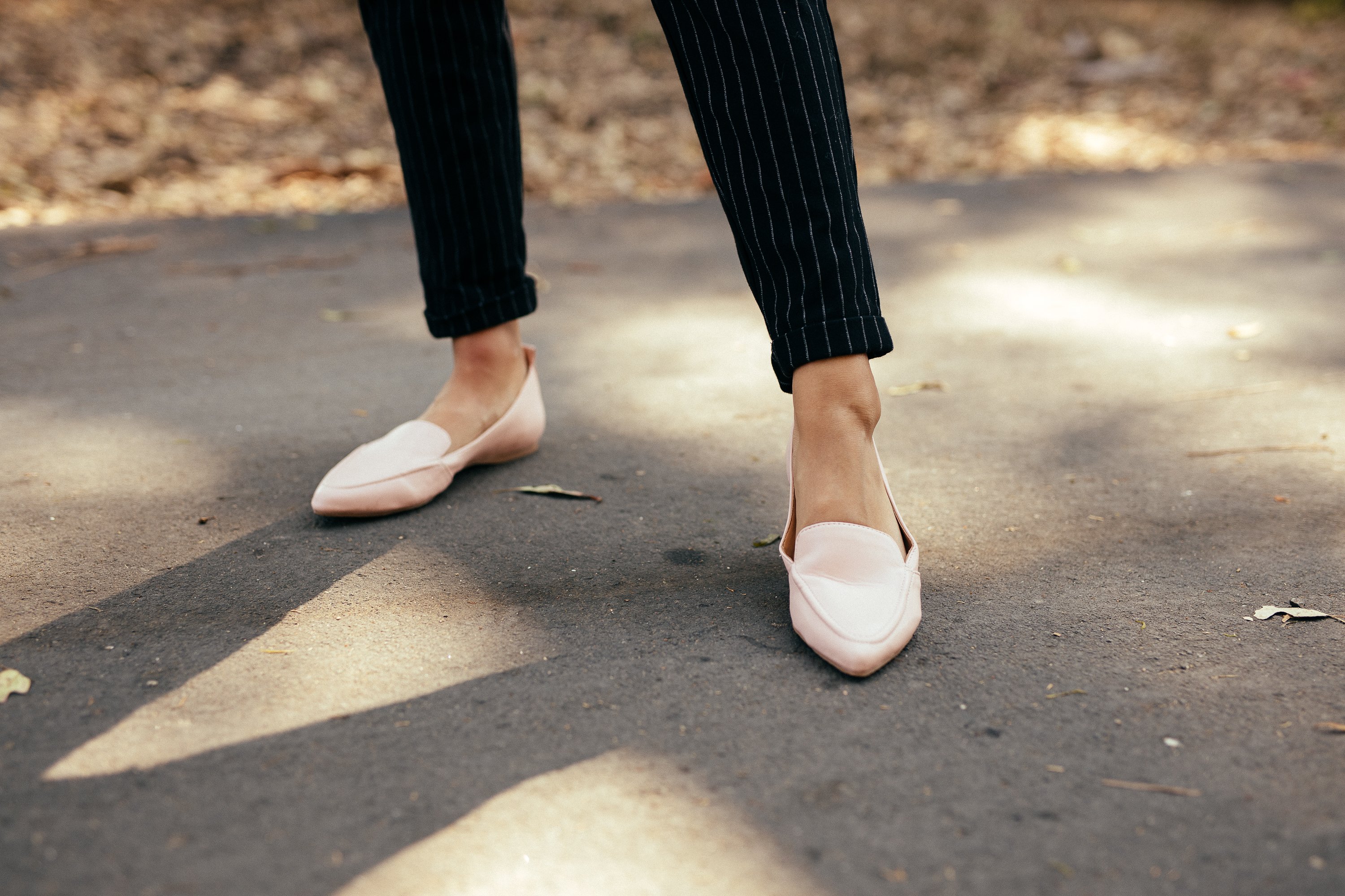 A pair of Women's Flat Socialite Pink shoes featuring a loafer-style front, pointed toe, and cushioned sole, made from faux-leather material.